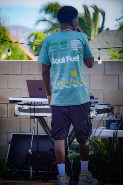 IE Native MillsWasChosen wearing a 'Soul Fuel' t-shirt standing outdoors with electronic equipment.
